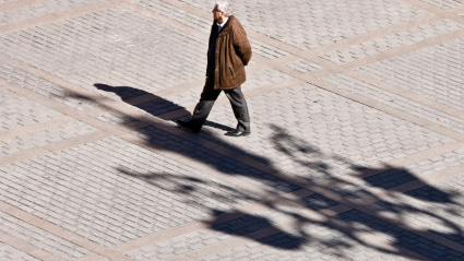 Hombre caminando por la Plaza Virgen de Los Reyes Sevilla Andalucía