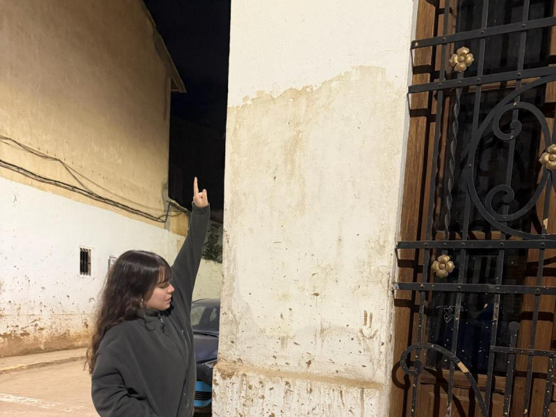 Laura Señala en una calle de Massanassa hasta donde llegó la corriente de agua