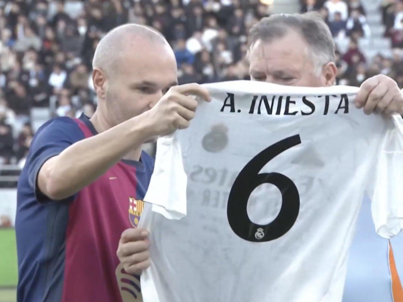 Camacho entrega una camiseta del Real Madrid a Iniesta.