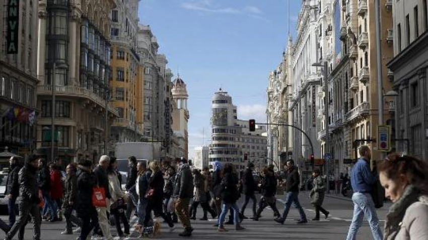 Personas cruzando por un paso de peatones en plena Gran Vía durante estas Navidades