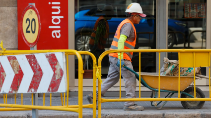Un obrero lleva una carretilla