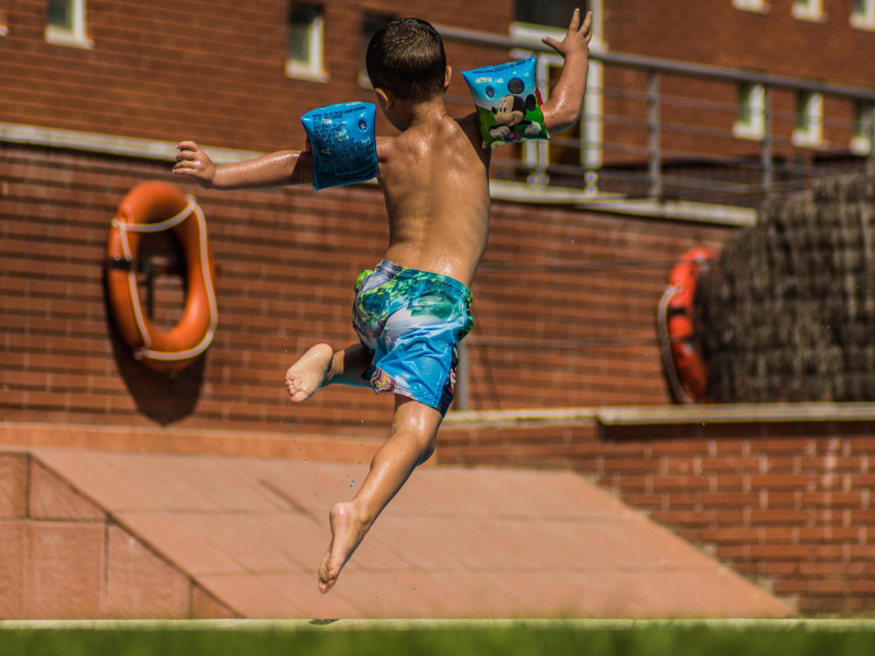 R3DPR8 Nino saltando a la piscina en vacaciones.