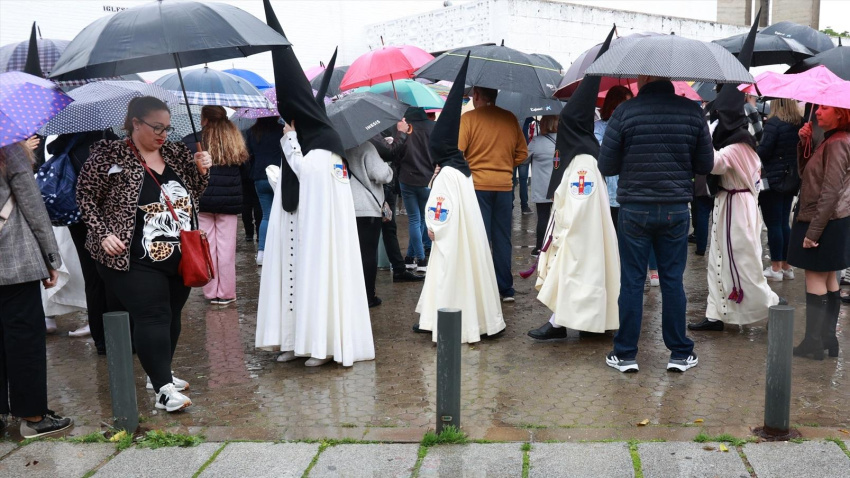 Nazarenos de la Hermandad del Cautivo de San Pablo salen de la Iglesia tras suspenderse por la lluvia su estación de penitencia. A 24 de marzo de 2024, en Sevilla (Andalucía, España). Inestabilidad, precipitaciones y bajas temperaturas protagonizan la Semana Santa en Andalucía.