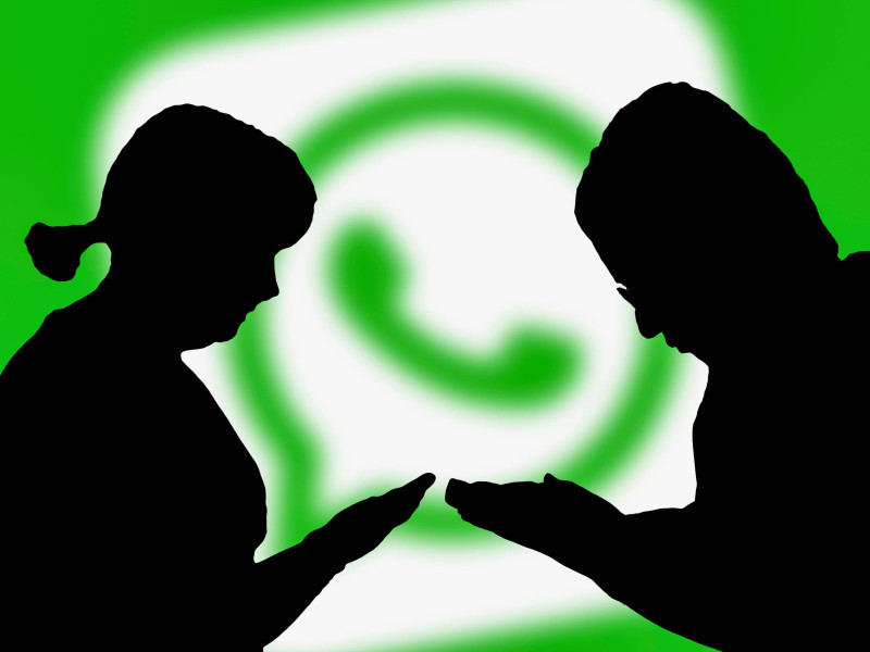 Siluetas de dos personas que se están comunicando a través de WhatsApp