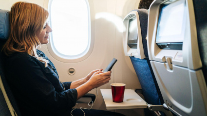 Una mujer utilizando su teléfono móvil en pleno vuelo