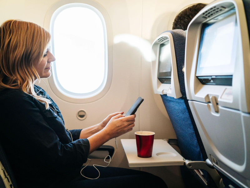 Una mujer utilizando su teléfono móvil en pleno vuelo