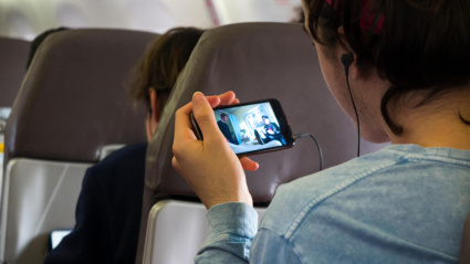 Un joven utiliza su teléfono móvil en pleno vuelo