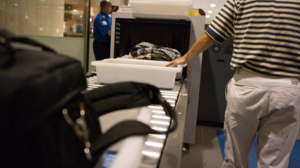 Control de seguridad en un aeropuerto con equipaje, maletas y zapatos