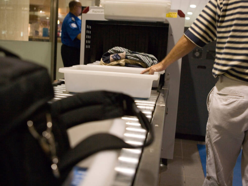Control de seguridad en un aeropuerto con equipaje, maletas y zapatos