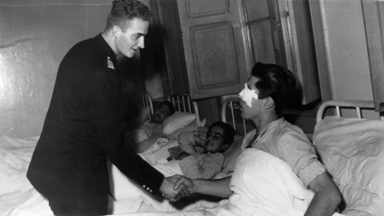 El entonces Príncipe Juan Carlos visita a un herido en Sidi Ifni