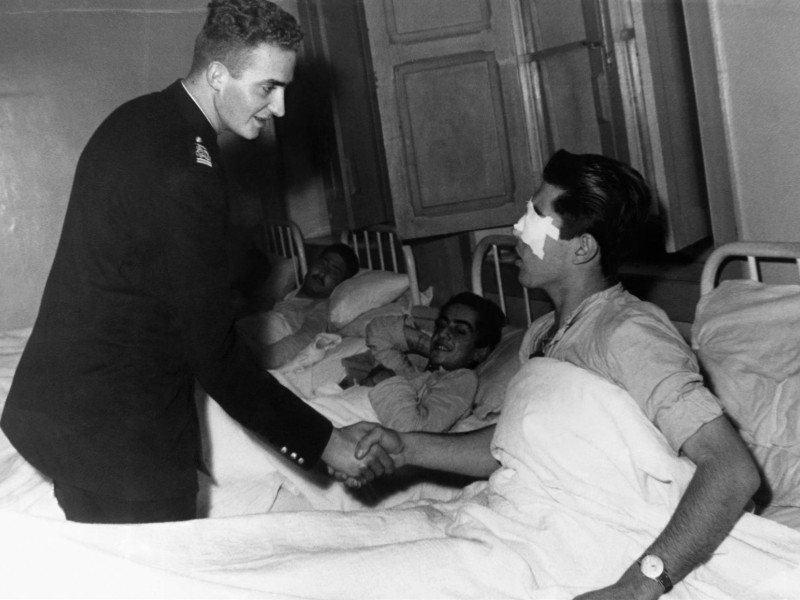 El entonces Príncipe Juan Carlos visita a un herido en Sidi Ifni