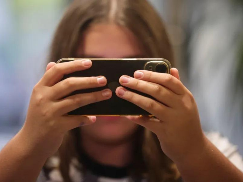 Una adolescente utilizando su teléfono móvil