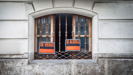 Carteles de 'se vende' y 'se alquila' en la ventana de un piso de Valencia