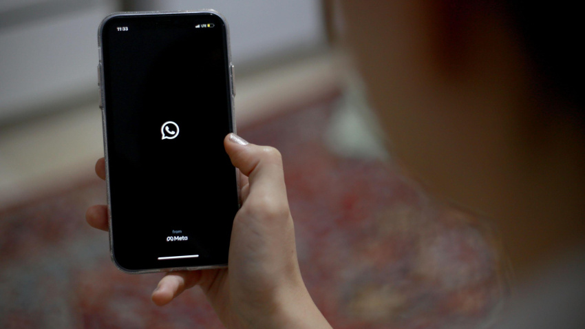 Una mujer mira el icono de WhatsApp en la pantalla de su móvil tras bloquear la aplicación