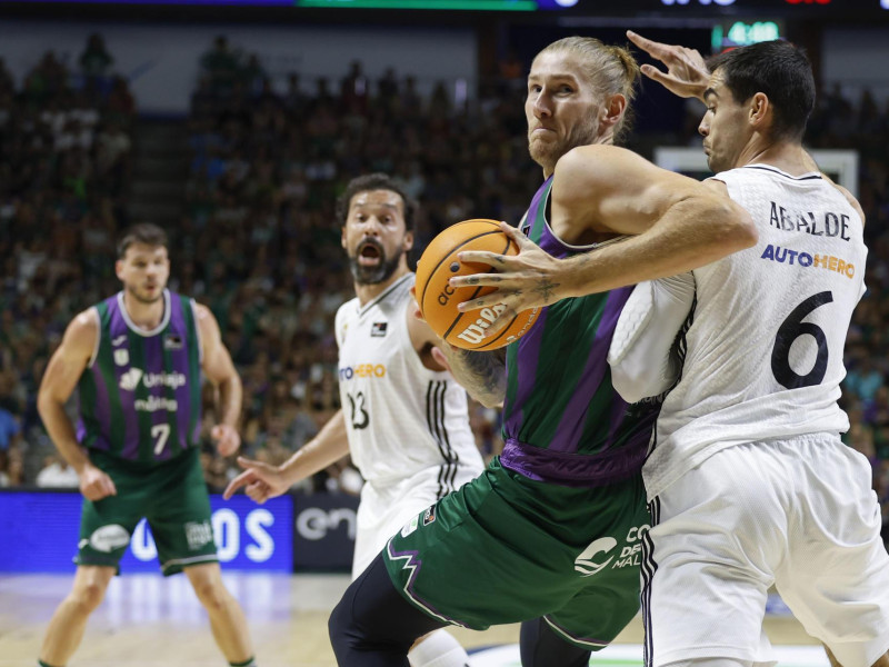 MÁLAGA, 15/06/2025.- El alero alemán del Unicaja Dylan Osetkowski (2d) en acción ante el alero del Real Madrid Alberto Abalde (d) durante el tercer partido de semifinales de la Liga Endesa de Baloncesto entreUnicaja y Real Madrid, este domingo en el Palacio de Deportes José María Martín Carpena de Málaga. EFE/ Jorge Zapata