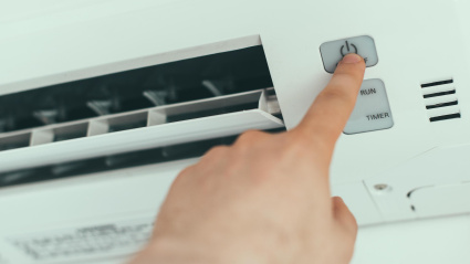 Un hombre apaga el sistema de aire acondicionado de su casa