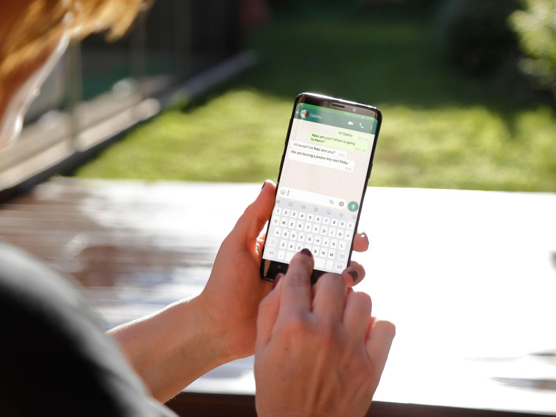 Una mujer usando WhatsApp en su smartphone