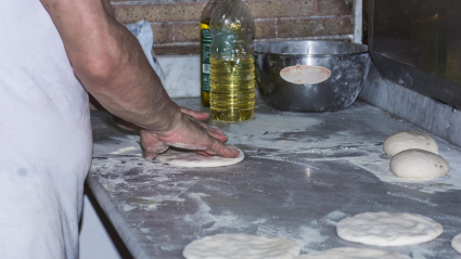 Una mujer haciendo pan en una panadería tradicional