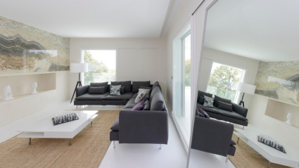 Un espejo grande situado en el lateral de un salón espacioso