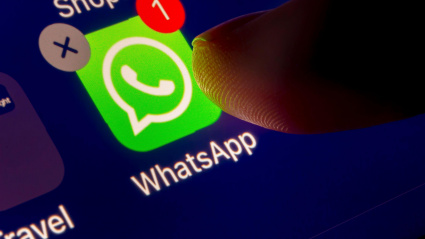 Una persona toca la pantalla de su teléfono móvil para acceder a WhatsApp