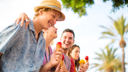 Cuatro amigos se ríen en grupo mientras se comen un helado