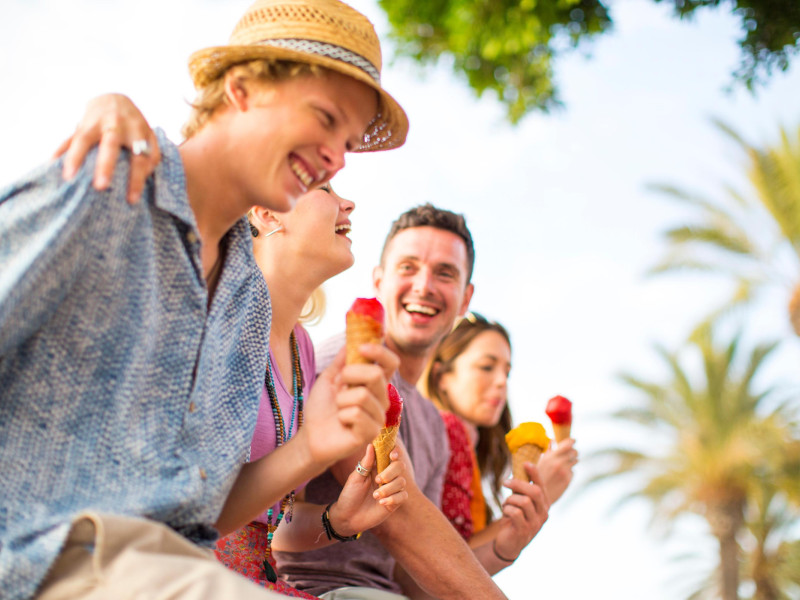 Cuatro amigos se ríen en grupo mientras se comen un helado