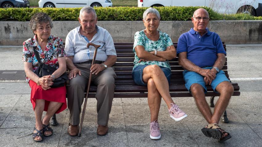 Varias personas mayores sentadas en un banco pasando la tarde en Santander