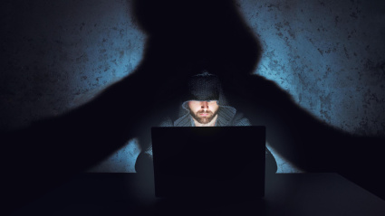 Un hacker frente a un ordenador portátil