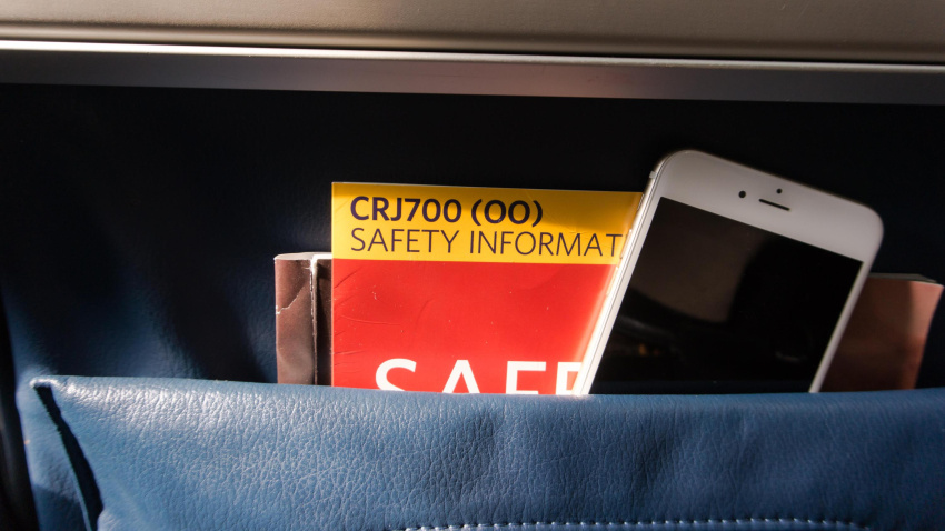 Un móvil iPhone en el bolsillo del asiento de un avión