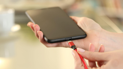 Un hombre pone a cargar su teléfono móvil