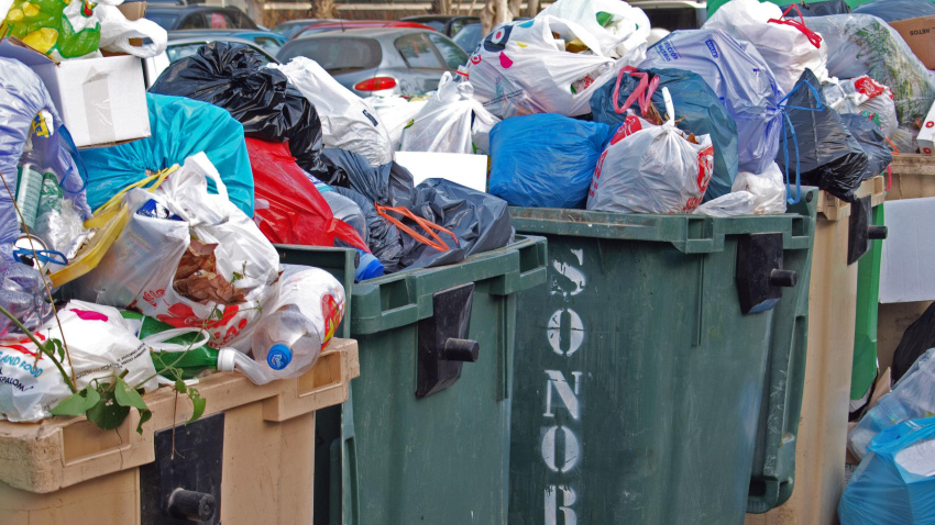 Cubo de basura lleno de residuos urbanos