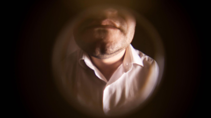 Un hombre visto desde la mirilla de casa