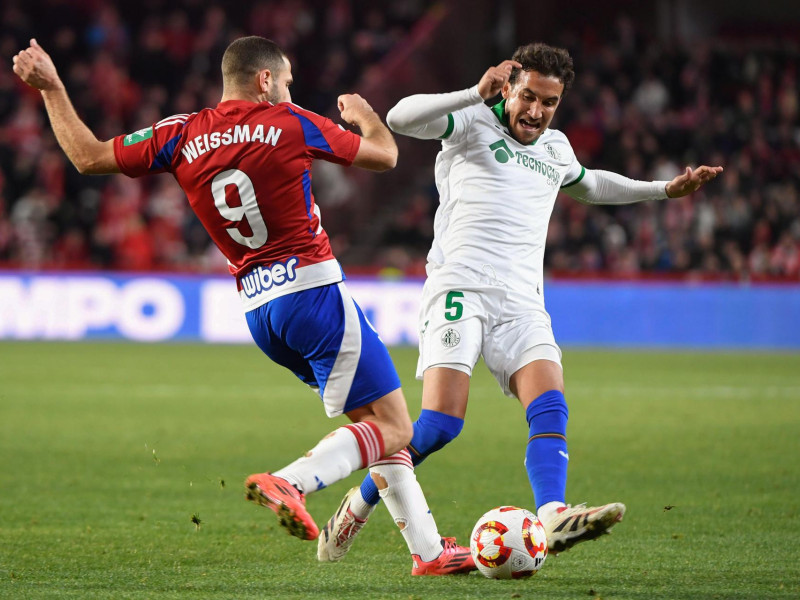 El delantero israelí del Granada Shon Weissman (i) pelea una posesión con el centrocampista del Getafe CF Luis Milla