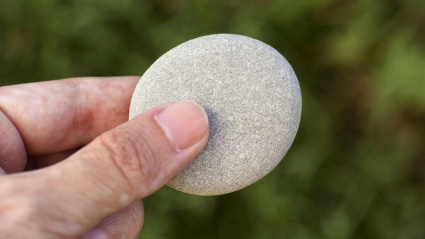 Un hombre sostiene una piedra en su mano