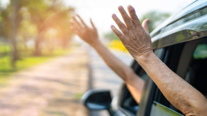 Dos personas sacan sus brazos por fuera de las ventanillas del coche