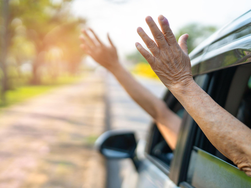 Dos personas sacan sus brazos por fuera de las ventanillas del coche