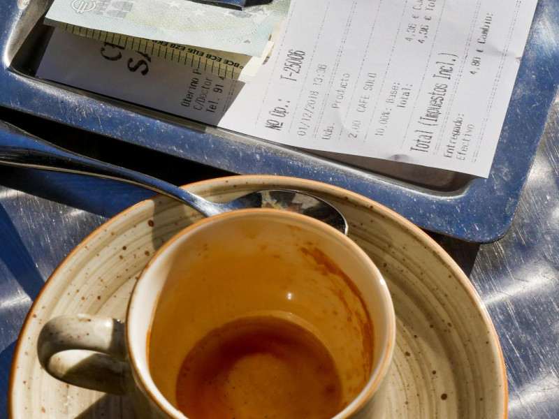 R8CY0P Empty cup of coffee and bill, on a cafe table, Madrid, Spain