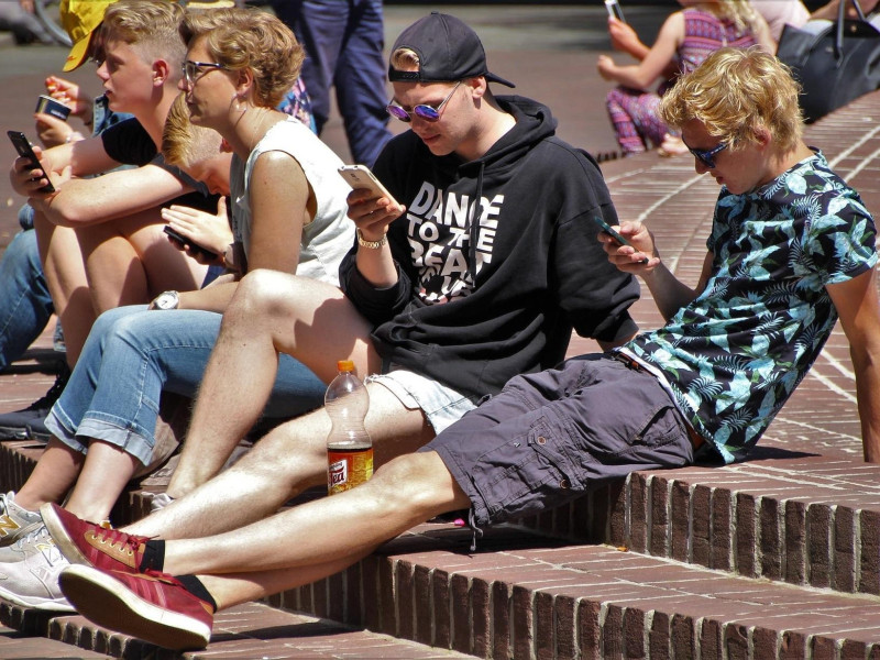 Jóvenes mirando teléfono móvil