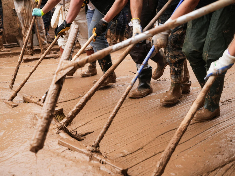 Voluntarios  retirando agua sucia de las calles durante las inundaciones de la DANA