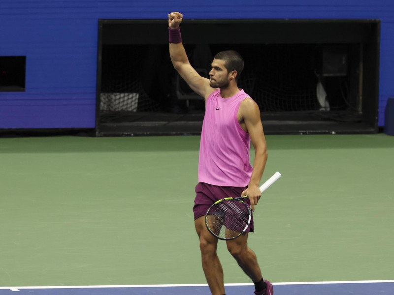 Carlos Alcaraz levanta el brazo derecho celebrando un punto en la final del US Open