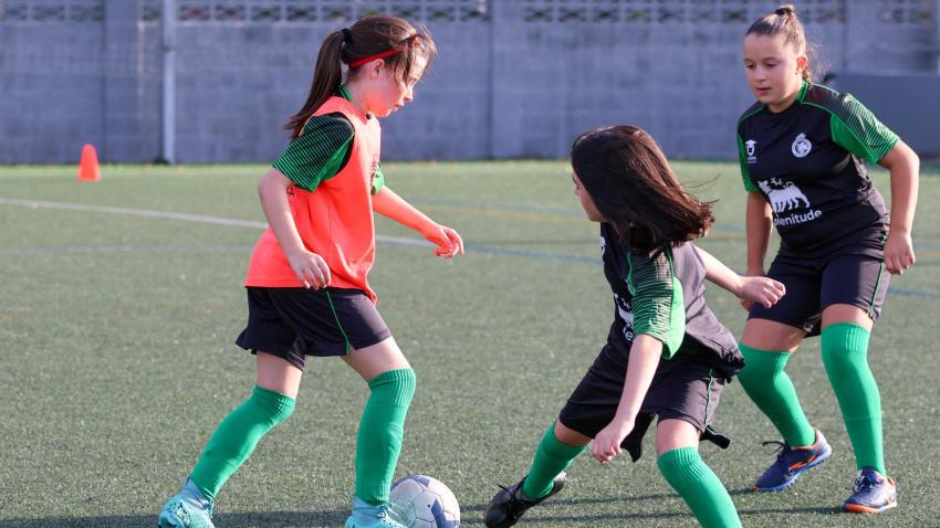 Tres niñas juegan al fútbol dentro de la Academia del Real Racing Club