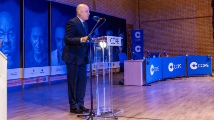 Juan Carlos Sevilla, director de COPE en Castilla-La Mancha, en su discurso inaugural. De fondo, paneles fotográficos con las estrellas de Cadena COPE