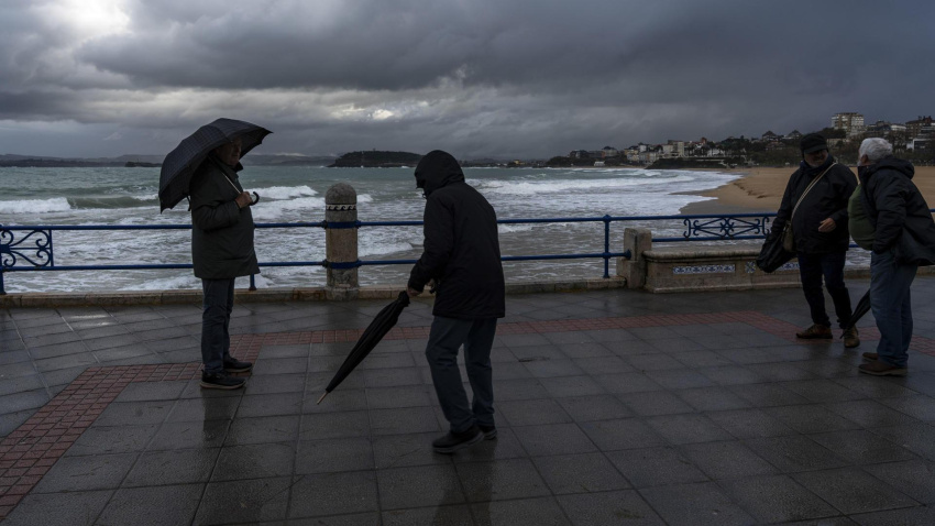 Algunas personas pasean con frío y lluvia en Santander