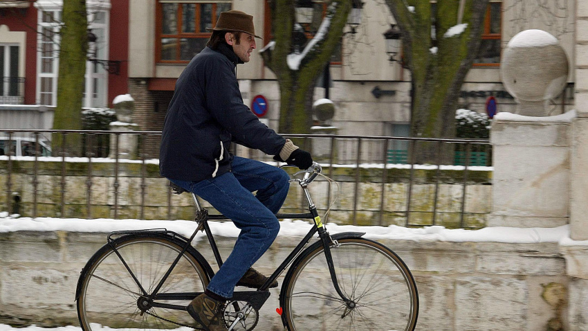 Un hombre pasea en bicicleta por las calles de Burgos nevadas