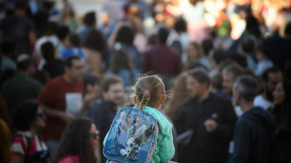 Una niña a hombros de su padre yendo al colegio