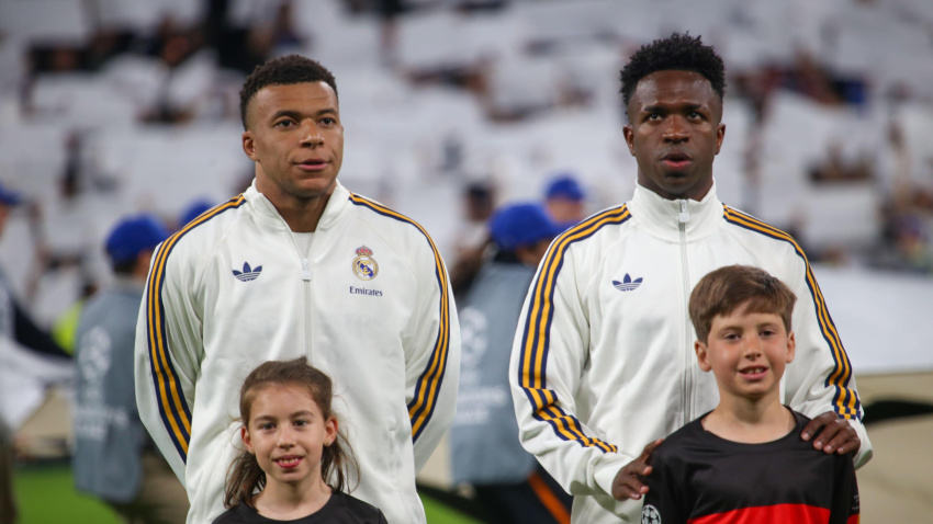 Los jugadores del Real Madrid Kylian Mbappé (10, izq.) y Vinícius Júnior (7, der.) escuchan el himno de la Champions League durante el partido de ida de los cuartos de final de la UEFA Champions League 2025-26 entre el Real Madrid y el Bayern de Múnich el 7 de abril de 2026 en el estadio Santiago Bernabéu de Madrid, España.