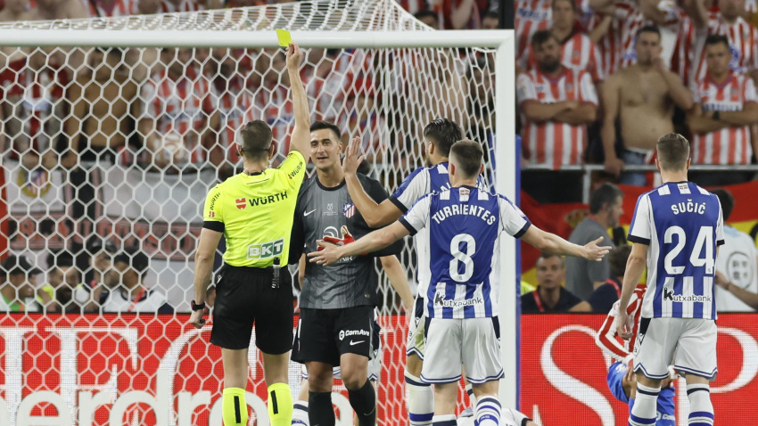 El colegiado Figuero Vázquez muestra tarjeta amarilla al guardameta argentino del Atlético de Madrid, Juan Musso, durante la final de la Copa del Rey que enfrenta a Atlético de Madrid y Real Sociedad este sábado en el estadio de La Cartuja, en Sevilla.