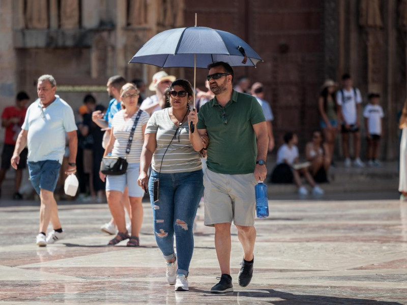 Dos personas con un paraguas para protegerse por el calor