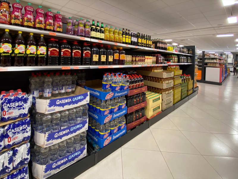 Un pasillo de un supermercado de Madrid con botellas de vino, gaseosa y aceite