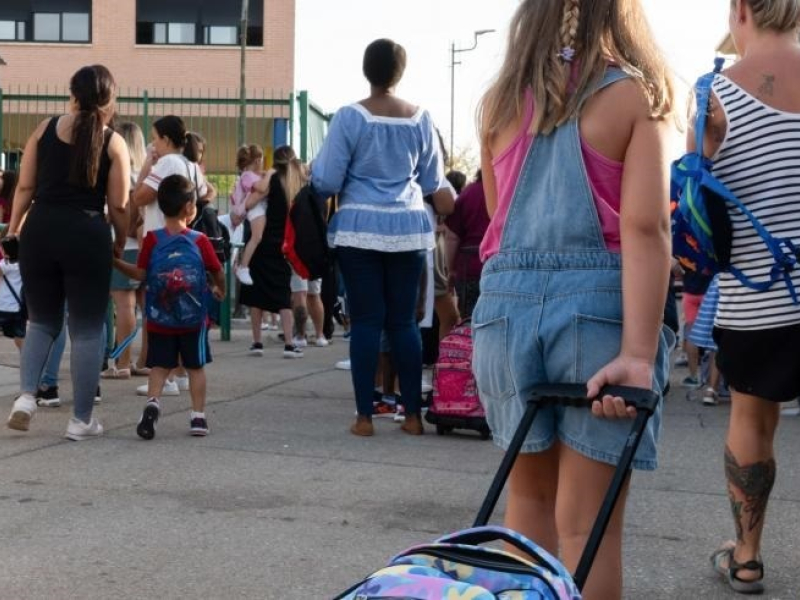 Niños y padres llegando a un colegio